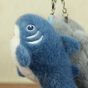 Dettaglio di portachiavi a forma di squalo in morbido peluche blu e grigio con anelli