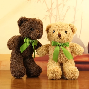 Detail of plush teddy bears in brown and tan with vibrant green satin silk scarves
