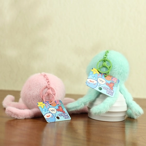 Detail of plush octopus keychains in pink and mint green with metallic clips