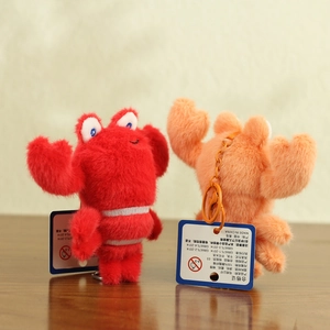 Detailed view of red and peach crab plush keychains with soft faux fur texture