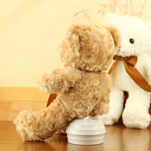 Detail of light brown curly teddy bear plush toy with a dark brown satin bow tie