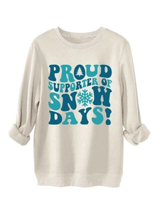 Close-up of Snow Days slogan and winter graphics on cream fleece sweatshirt