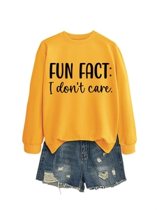 Detail of ginger yellow sweatshirt with FUN FACT text and distressed denim shorts
