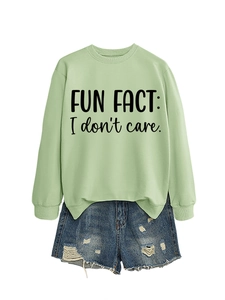 Flat lay of light green crewneck sweatshirt with Fun Fact print and denim shorts