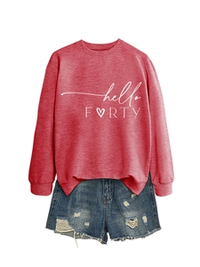 Detail of hello FORTY pink sweatshirt with heart icon paired with distressed denim shorts