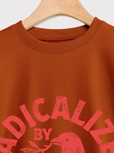 Détail du col côtelé et de l'imprimé graphique vintage sur le sweat-shirt caramel