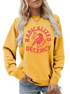 Détail de l'imprimé RADICALIZED BY BASIC DECENCY sur le sweat jaune à manches longues
