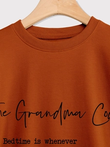 Detalle de la sudadera naranja caramelo con estampado The Grandma Code y cuello de canalé