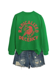 Détail du sweat vert à col rond avec motif imprimé et short en jean bleu avec franges