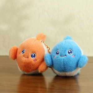 Detail of plush orange and blue ocean animal keychains with fine embroidery on wood
