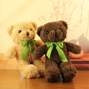 Detailed view of plush teddy bears in beige and brown with green satin silk bows