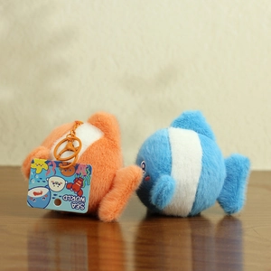 Detail of plush orange and blue clownfish keychains with Sea World tags on wood