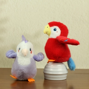 Close-up of soft plush bird pendants in purple and red colors on a wooden surface