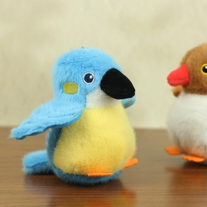 Close-up of plush bird pendant featuring embroidery eyes and vibrant blue fabric