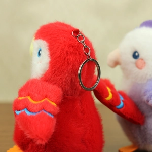 Detailed view of red plush parrot keychain with colorful embroidery and metal ring