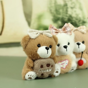 Trois porte-clés ours en peluche avec accessoires biscuit et cerise sur fond vert