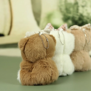 Vue détaillée du dos des peluches d'oursons en marron, blanc et beige avec un nœud