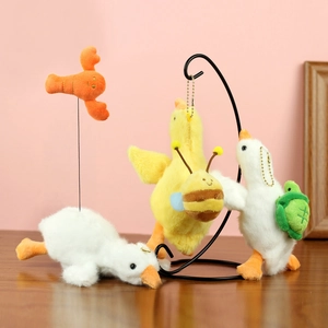 Porte-clés oie blanche en peluche avec breloques abeille et homard sur surface en bois