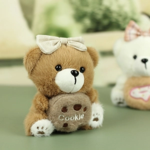 Détail d'un ours en peluche marron avec broderie Cookie et nœud à carreaux soigné