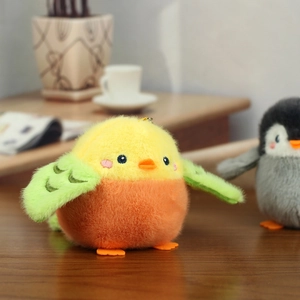 Close-up of a cute yellow and orange plush bird keychain with soft green stitched wings