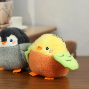 Close-up of cute plush penguin and sparrow charms with soft faux fur and metal keychains