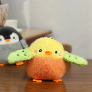 Close-up of yellow and orange plush bird pendant on a wooden table with soft focus bokeh