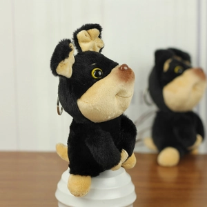 Primo piano di un simpatico portachiavi a forma di cane in peluche nero e marrone