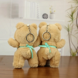 Detailed back view of two plush bears with mint green bows and silver metal keychains