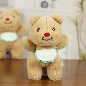 Close-up of cute plush bear with soft brown fur, red nose and white ruffled bib detail