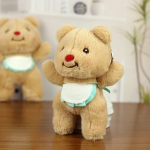 Detail of cute plush bear keychain with red nose and lace bib for school bags