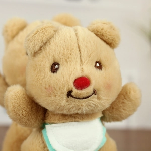Close-up of plush butter bear with a red flocked nose and green-edged white bib detail