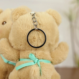 Close-up of the soft plush texture and mint green ribbon bow on the brown bear keychain