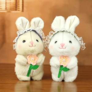 Primer plano de conejitos de peluche con gorros de encaje y flores decorativas