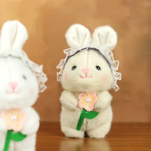 Detalle de conejo de peluche con diadema de encaje y pequeña flor bordada
