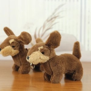 Détail de deux porte-clés chien en peluche marron avec fourrure douce sur bois