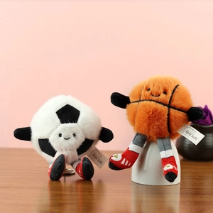 Gros plan de porte-clés peluches foot et basket avec baskets sur surface en bois