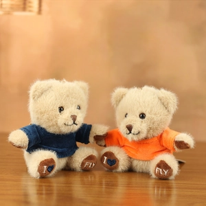 Detail of plush teddy bear charms featuring knitted sweaters and heart embroidery on paws