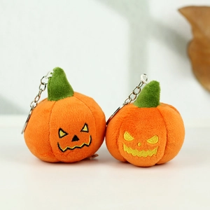 Close-up of plush Halloween pumpkin keychains with embroidered smiles and metal clips