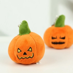 Macro detail of plush Halloween pumpkin keychain with embroidery and metal clip