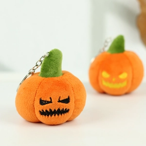 Detailed view of plush Halloween pumpkin charms with embroidered funny expressions