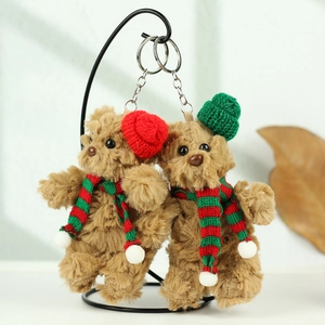 Nahaufnahme von süßen Weihnachts-Plüschbären mit Strickmützen und Schals am Haken