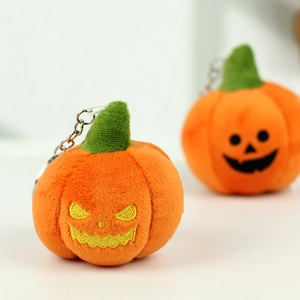 Close-up of plush Halloween pumpkin keychains with detailed evil and smiling embroidery