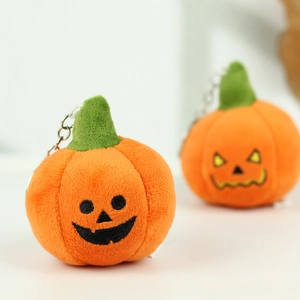 Detailed macro view of orange pumpkin plush keychains with festive spooky embroidery