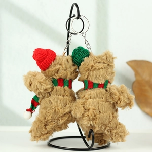 Detail von Plüsch-Weihnachtsbären mit roten und grünen Strickmützen und Streifenschals