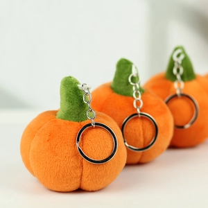 Close-up of soft orange plush pumpkin keychains with green stems and silver metal rings