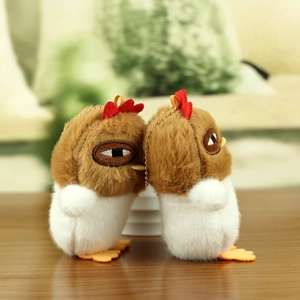 Close-up of cute cartoon chick plush keychain with soft fur and golden bead chains