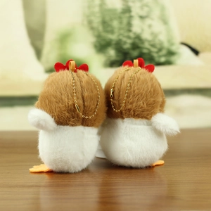 Close-up of cute plush chick keychains with soft fur texture on a wooden desk