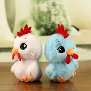 Close-up of pink and blue plush chick pendants with soft fur texture on wooden desk