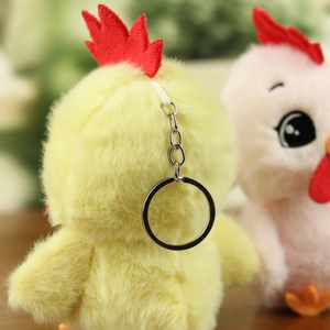 Detailed macro view of yellow plush chick pendant with red comb and silver metal keychain