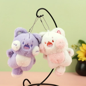 Detailed embroidery on purple and white plush cat keychains hanging on a metal stand